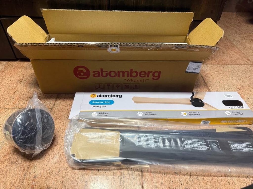 Unboxing of Atomberg Renesa Halo Smart BLDC ceiling fan with open box, packaged blades, and motor unit laid out for inspection